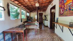 a room with benches and tables in a house at Bela Oyá Casa Hostel in Vale do Capao