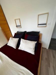 a bedroom with a bed with red and white pillows at Charmant appart, avec parking à quelques minutes du départ des télécabines in Crans-Montana