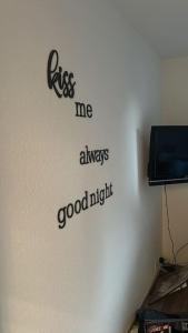 a wall with a sign that readskiss me always goodnight at Charmant appart, avec parking à quelques minutes du départ des télécabines in Crans-Montana +25 photos
