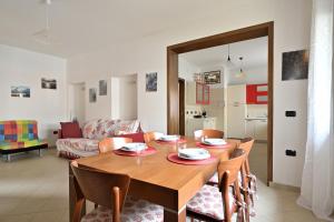 a living room with a wooden table and chairs at Casa Mariposa in Alghero