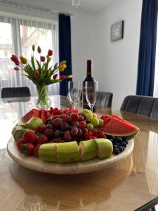 a plate of fruit on a table with wine glasses at Tatrzański Domek & SPA in Poronin