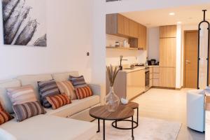 a living room with a couch and a table at Lusso Hometels Missoni Business Bay in Dubai