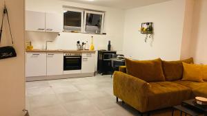 a living room with a couch and a kitchen at TuaCasa - Gemütliches Souterrain Apartment in Lippstadt