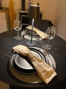 a table with a plate with a napkin and wine glasses at TuaCasa - Gemütliches Souterrain Apartment in Lippstadt +6 photos