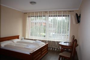 a bedroom with a bed and a window and a table at Der Gutschmecker Bad Segeberg in Bad Segeberg
