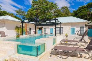 a swimming pool with two lounge chairs and a swimming poolvisor at Villas VR Beachwalk Avellanas in Playa Avellana +98 photos