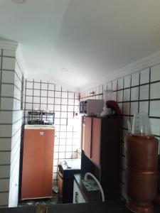 una pequeña cocina con nevera y encimera en Casita da barra, en Búzios 25 fotos más