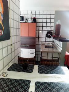 Una pequeña cocina con una mesa y un fregadero. en Casita da barra, en Búzios