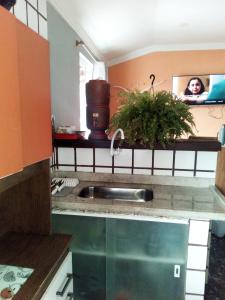 una cocina con fregadero y una mujer en un espejo en Casita da barra, en Búzios