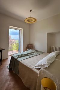 a bedroom with a large bed and a window at Merumalia Wine Resort in Frascati