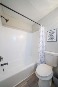 a bathroom with a white toilet and a bath tub at OV Mosaic - Topaz Suite in North Camellia Acres