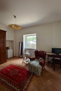 a living room with a chair and a table at Merumalia Wine Resort in Frascati