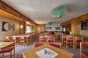 a dining room with wooden tables and chairs at Horský Hotel Kubát in Benecko