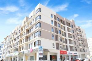 a large white building on a city street at City Gem BAQ - 305 in Muscat