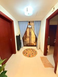 a hallway with a door and a rug on the floor at City Gem BAQ - 305 in Muscat +9 photos