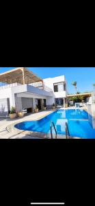a large blue swimming pool in front of a building at Dar Zina in Al Maqārisah