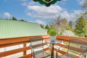 艾肯Aiken Apt with Garden-View Balcony Half-Mi to Dtwn!的阳台上有一个带两把椅子和一张桌子的露台