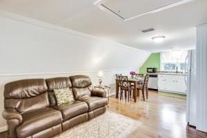 艾肯Aiken Apt with Garden-View Balcony Half-Mi to Dtwn!的配有皮沙发和桌子的客厅