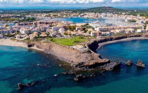 eine Luftansicht auf eine Stadt und das Meer in der Unterkunft Mini Loft avec Cinema et Terrasse - Cap D'Agde in Cap d'Agde