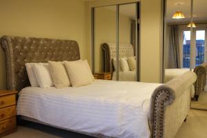 Un dormitorio con una cama grande con un espejo grande. en Luxury 6-Bedroom House 5 minutes from Bicester Village Shopping Outlet, en Chesterton