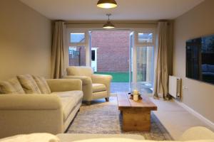 Una sala de estar con un sofá y sillas y una mesa. en Luxury 6-Bedroom House 5 minutes from Bicester Village Shopping Outlet, en Chesterton