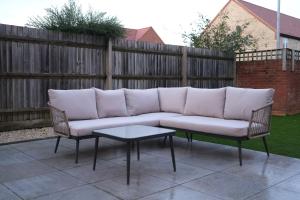 un sofá y 2 sillas en el patio en Luxury 6-Bedroom House 5 minutes from Bicester Village Shopping Outlet, en Chesterton