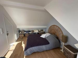 a bedroom with a large bed in a attic at Charmante maison Cabourgeaise in Cabourg