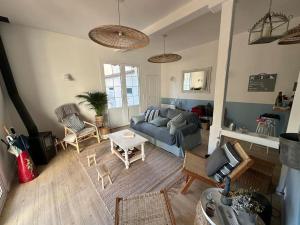 a living room with a couch and a table at Charmante maison Cabourgeaise in Cabourg