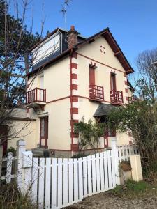 a white house with a white fence in front of it at Charmante maison Cabourgeaise in Cabourg