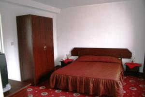 1 dormitorio con 1 cama con colcha roja. en Pensiunea Tranzit Sinaia, en Sinaia