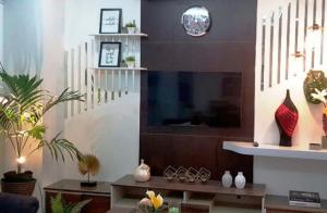 a living room with a tv and a table with vases at Tony's Place - Second Level in Santa Maria
