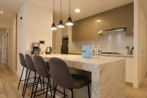 リマにあるCharming 2BR with Balcony in Mirafloresのバースツール付きの大きな大理石のカウンターを備えたキッチン