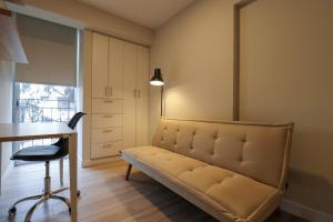 リマにあるCharming 2BR with Balcony in Mirafloresのソファ、テーブル、デスクが備わる客室です。