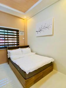 a bedroom with a bed with a picture on the wall at FYLL Homes Ysabella Suite Calvario St Cavinti Town Proper in Cavinti