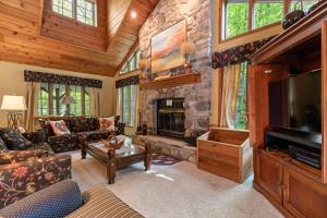 a living room with a stone fireplace and a tv at Birch Haven by Simple Life Rentals in Sister Bay +14 photos