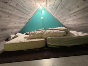 a bed in a room with a blue wall at Villa Boston in La Bourboule