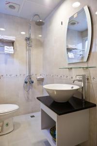 a bathroom with a sink and a toilet and a mirror at Ibizakenting Hotel in Kenting