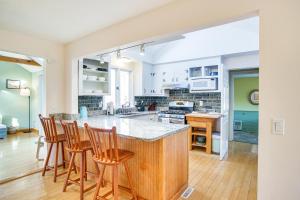 a kitchen with a island with bar stools at Chatham Home with Spacious Deck 2 Mi to Beaches! in Chatham