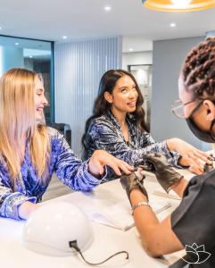 a group of three women sitting at a table playing with shoes at Knightsbridge Luxury Escape in Cape Town +23 photos