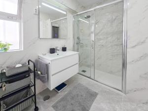 ein weißes Badezimmer mit Dusche und Waschbecken in der Unterkunft Apartment Concorde Sky Vista Mar in Portimão + 24 Fotos