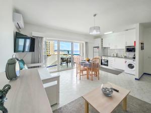 eine Küche und ein Wohnzimmer mit Tisch und ein Esszimmer in der Unterkunft Apartment Concorde Sky Vista Mar in Portimão