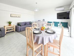 ein Wohnzimmer mit einem Tisch mit Stühlen und einer Couch in der Unterkunft Apartment Concorde Sky Vista Mar in Portimão