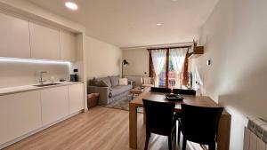 a kitchen and living room with a table and chairs at BPirineos-Llardana in Benasque +16 photos