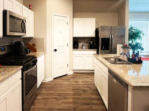 a kitchen with white cabinets and stainless steel appliances at Business Ready 2 Kings Private Office in Lake Charles