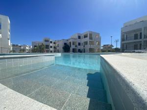 ein Pool mit blauem Wasser vor den Gebäuden in der Unterkunft San Rocco one bed Apartments 4A1 9 in Isca sullo Ionio + 25 Fotos