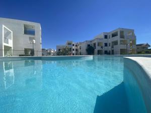 a large swimming pool in front of some buildings at San Rocco one bed Apartments 4A1 9 in Isca sullo Ionio