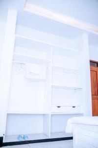 a room with white cabinets and a white table at Comfortable and Spacious house in Arusha