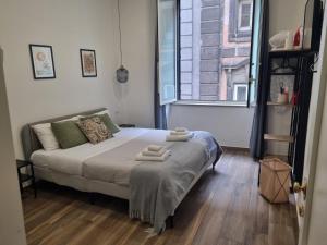 a bedroom with a bed with two towels on it at Il Fondaco all'Archivio Storico in Naples