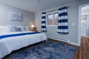 ein Schlafzimmer mit großem Bett und Fenster in der Unterkunft Marina Cottage by Simple Life Rentals in Baileys Harbor