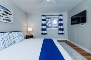 ein Schlafzimmer mit einem blau-weißen Bett und einem Fenster in der Unterkunft Marina Cottage by Simple Life Rentals in Baileys Harbor